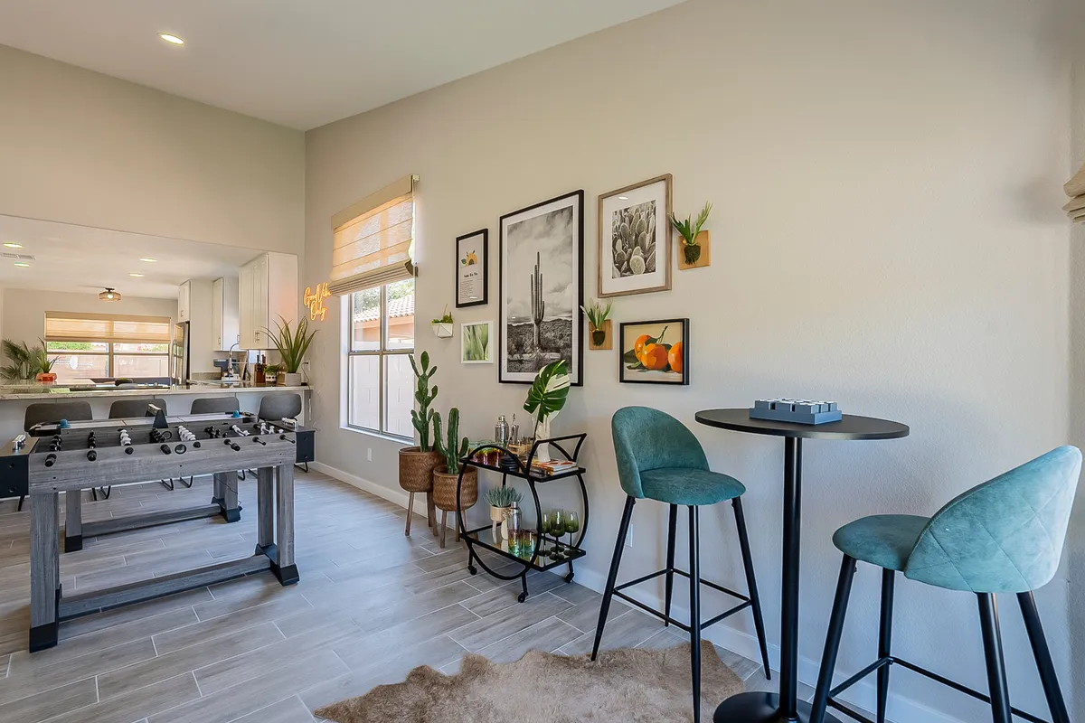 This interior photo features a foosball table as the main attraction, with art adorning the wall and bar stools providing casual seating. The mood is playful yet relaxed, and the room design encourages socializing and friendly competition—a true centerpiece for family fun and gathering.