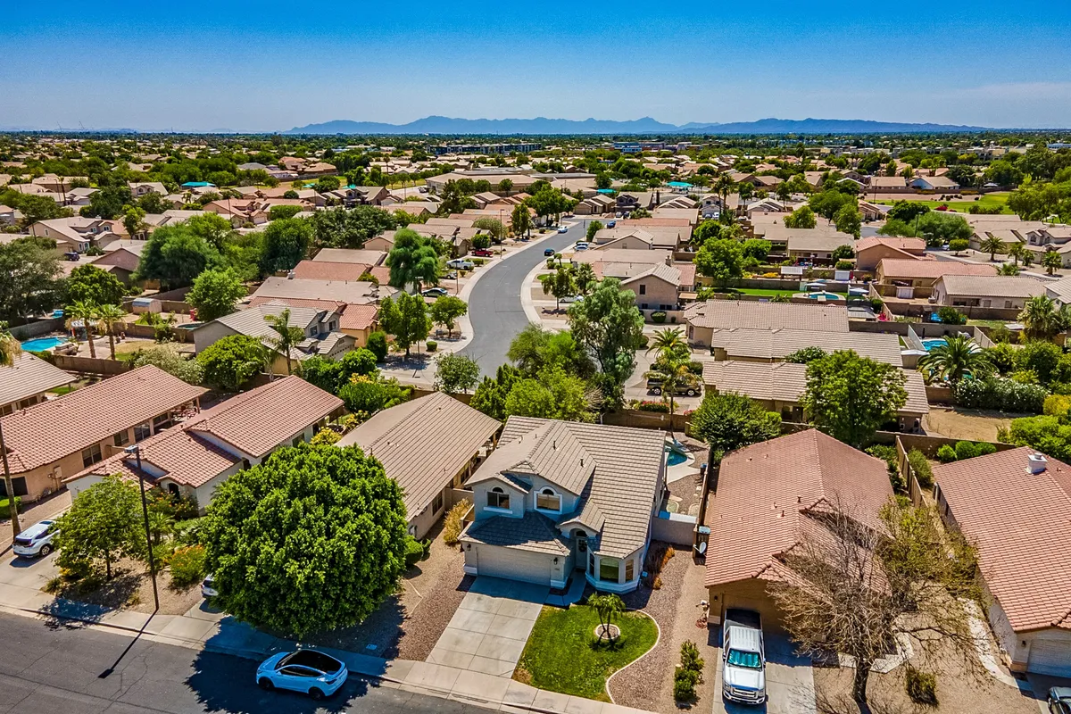 A curved residential street lined with lush greenery and inviting houses, offering a peaceful, community-oriented vibe. The leafy setting hints at nearby parks, walkable neighborhoods, and local exploration opportunities.